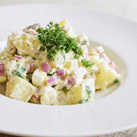 Vibrant image of homemade potato salad with fresh parsley, perfect for a picnic.