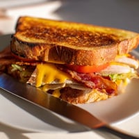 Golden, buttery sourdough slices sandwich roasted turkey, crispy bacon, fresh lettuce, juicy tomato, and melted cheddar in this Turkey Club Grilled Cheese.